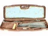 an open suitcase with clothes inside of it on a white surface