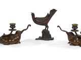 three bronze figurines of birds and a bird on a branch