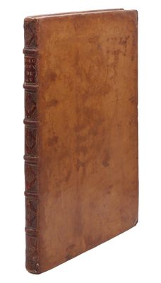 un vieux livre à la couverture brune posé sur une surface blanche