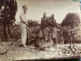 an old photo of a group of men standing around a dead animal