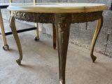 une petite table avec un plateau en marbre et des pieds en or
