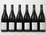 six bouteilles de vin sont alignées sur une table