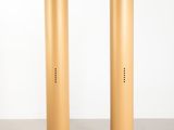 pair of gold metal pedestals in a white room with a white wall