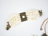 a white bracelet with a metal clasp and a white bead
