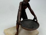statue of a man holding a bowl on a marble base
