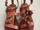une paire de sandales pour femme ornées de franges et de pompons