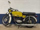 a yellow and black motorcycle parked in front of a blue and white wall