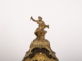 une statue représentant un homme tenant un marteau au sommet d'une horloge