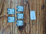 quatre cartes micro SD posées sur une table en bois, à côté d'une feuille de papier