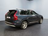 the back end of a blue volvo suv parked in a showroom