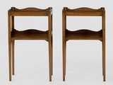 two wooden chairs with a shelf on each side of them