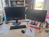 a desk with two monitors and a keyboard on it