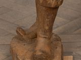 a statue of a man standing on top of a wooden block