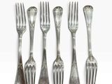 six forks and spoons are arranged in a row on a white surface
