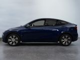 the blue car is parked on the concrete floor in the room