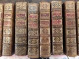 many old books stacked on top of each other on a table