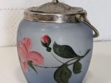 a blue glass jar with a pink flower on it