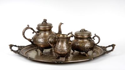 trois théières en argent et un plateau sur fond blanc
