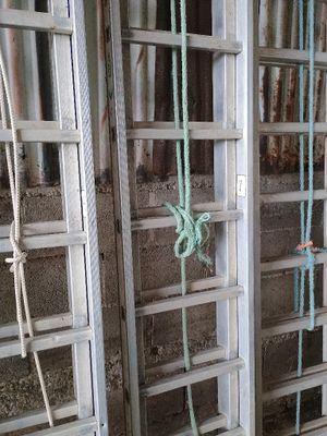 un homme qui se tient à côté d'une cage entourée de cordes