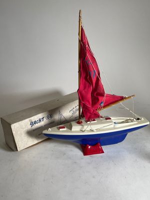 a small sailboat with a red sail on it