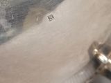 a close up of a silver plate with a handle