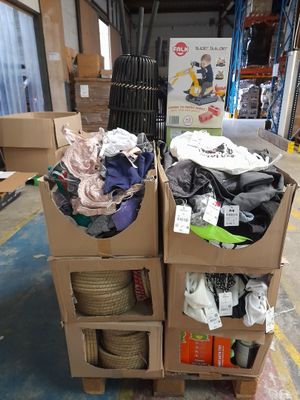 Des cartons de vêtements sont empilés les uns sur les autres dans un entrepôt