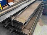 several pieces of steel are stacked on top of each other in a warehouse