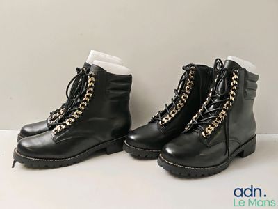 deux paires de bottes noires ornées de chaînes dorées