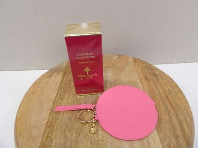 a pink purse and a pink keychain on a wooden table