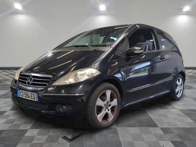 une photo d'une mercedes noire de classe b garée sur un sol en damier