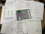 un livre posé sur une pile de papiers, elle-même posée sur une table