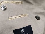 a close up of a suit with a tie and a button