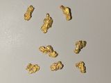 quelques pépites d'or sont éparpillées sur une surface blanche