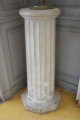 a white pedestal with a clock on top of it