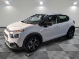 une voiture blanche est garée dans une pièce au sol à carreaux
