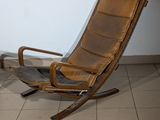 a brown leather chair sitting in a corner of a room
