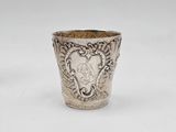 an old silver cup sitting on top of a white table