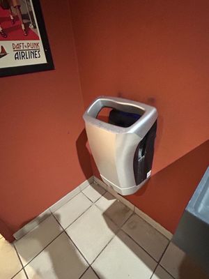a urinal in the corner of a bathroom with a sink