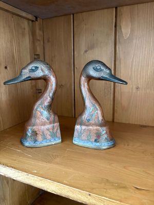 deux statues de canards posées sur une étagère dans une pièce