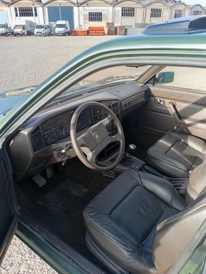une voiture verte avec des sièges et un tableau de bord en cuir noir
