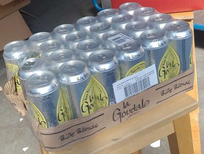 many cans of soda sitting on a wooden table