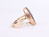 a close up of a gold ring with a black stone in it
