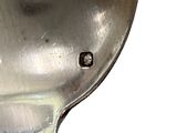 a close up of a silver spoon with a bird on it