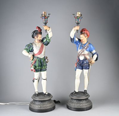 pair of figurines of two men with hats and a sword