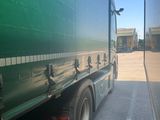 a green semi truck that is parked in a lot