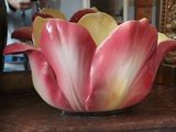 a pink and yellow flower sitting in a vase on a table