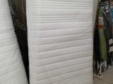 Plusieurs matelas sont empilés les uns à côté des autres dans une pièce.