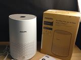 a white speaker sitting next to a box on a table