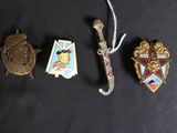 three badges and a sword are laying on a black surface