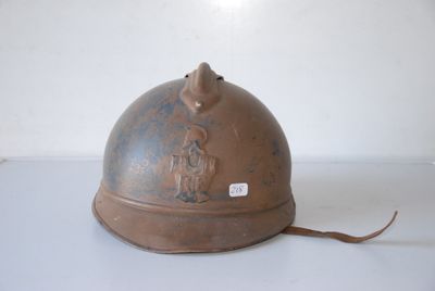 a brown helmet on a white surface with a sticker on it